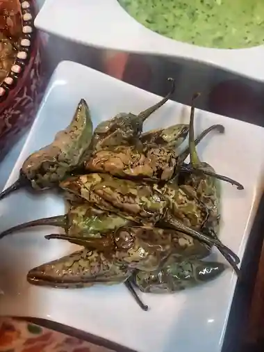 Tali hui hari mirchen, blistered fried green chillies served with green chutney